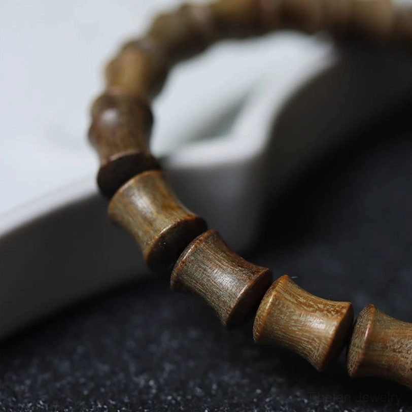 Tibetan nine-eye dzi green sandalwood bracelet complete product showing elastic cord construction and bead arrangement