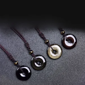 Tibetan obsidian protection necklaces collection - black, gold sheen, and rainbow variants displayed in flat lay on dark textured surface