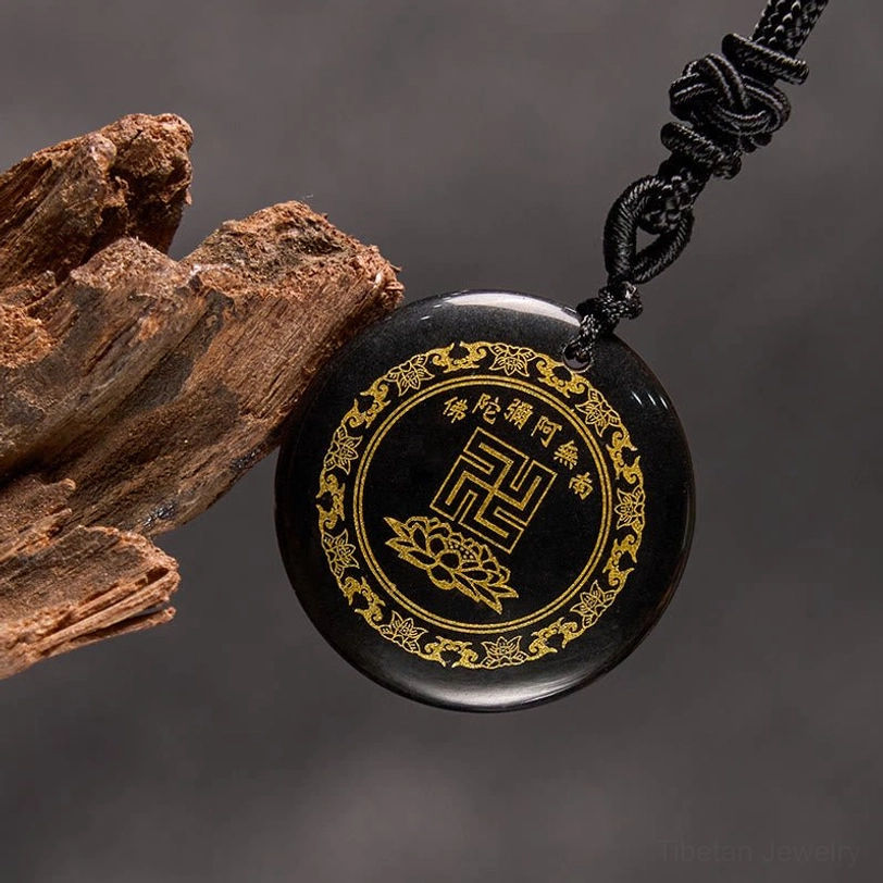 Black obsidian Buddhist necklace with braided rope and wooden prop three-quarter view