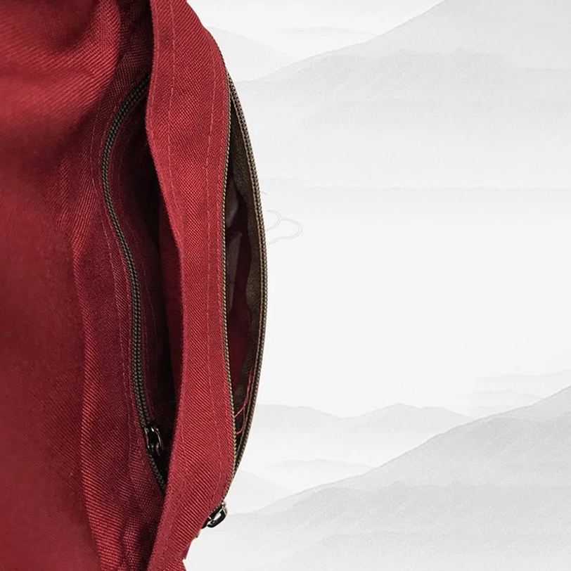 Close-up detail of Tibetan OM bag interior zipper pocket showing dark zipper trim, woven canvas texture, burgundy fabric
