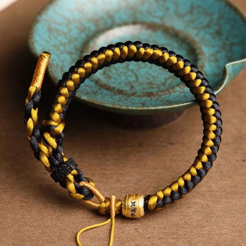 Handcrafted Tibetan om mani padme hum protection bracelet with engraved metal charm bead three-quarter angle