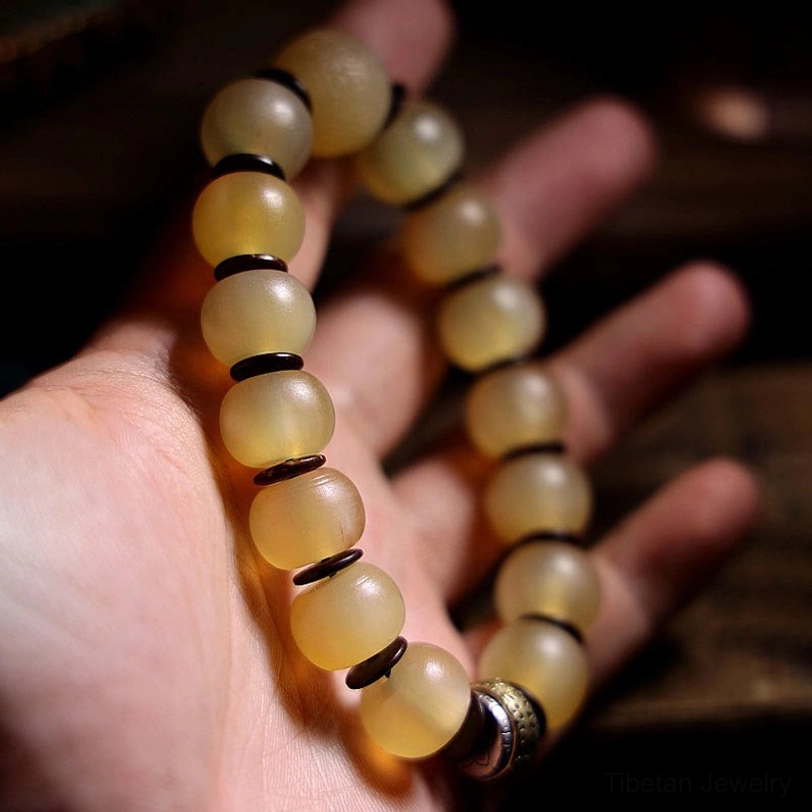 Handcrafted sheep horn Om Mani bracelet worn on hand showing natural bone texture and metal ring clasp