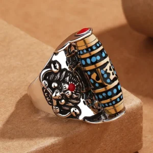 Tibetan Om Mani Padme Hum rotating dzi bead ring with Garuda protection symbol, silver copper finish with red gem inlay, three-quarter view