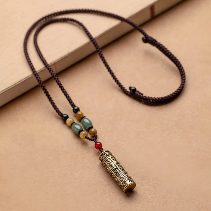Tibetan Om Mani Padme Hum agate necklace with braided rope, mixed stone beads, and brass pendant on light background