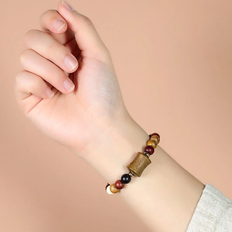 Tibetan Om Mani Padme Hum sandalwood bracelet worn on wrist showing fit and comfort with warm background lighting