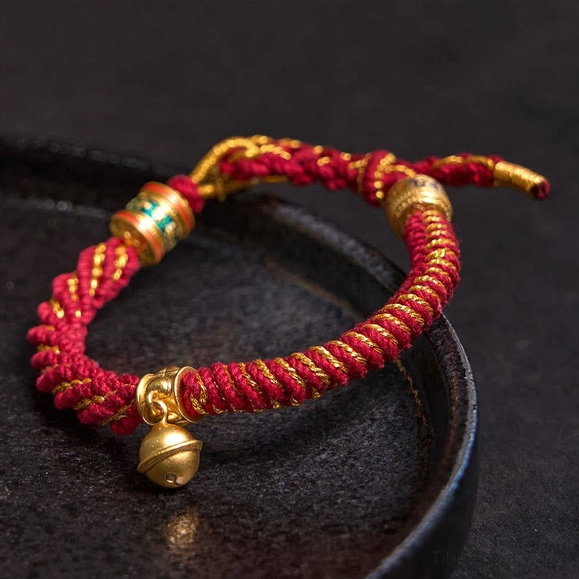 Handmade Tibetan Buddhist bracelet with braided natural cord showing authentic craftsmanship and traditional metal details