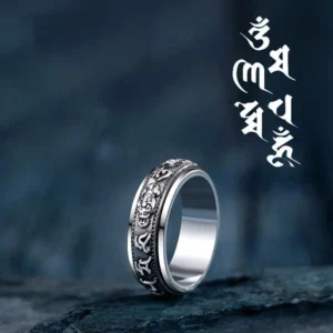 Tibetan Om Mani Padme Hum Pixiu rotatable silver ring with engraved mantras on dark stone backdrop