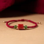 Tibetan Om Mani Padme Hum red cinnabar blessing bracelet with braided rope, engraved mantra beads and green jade accents
