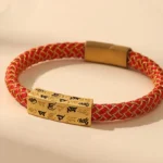 Tibetan Om Mani Padme Hum red and gold rope bracelet with engraved mantra plaque and magnetic metal clasp, handcrafted spiritual jewelry