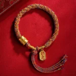 Handmade Tibetan Om Mani Padme Hum Ruyi multicolor braided bracelet with gold pendant charm flat lay