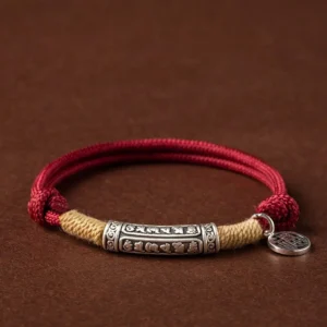 Tibetan handmade om mani padme hum sterling silver bracelet with red cord and fu character charm on dark background