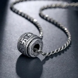 Tibetan Om Mani Padme Hum silver barrel pendant necklace with twisted rope chain, overhead view showing intricate Sanskrit engravings