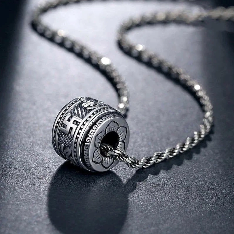 Tibetan Om Mani Padme Hum silver barrel pendant necklace with twisted rope chain, overhead view showing intricate Sanskrit engravings