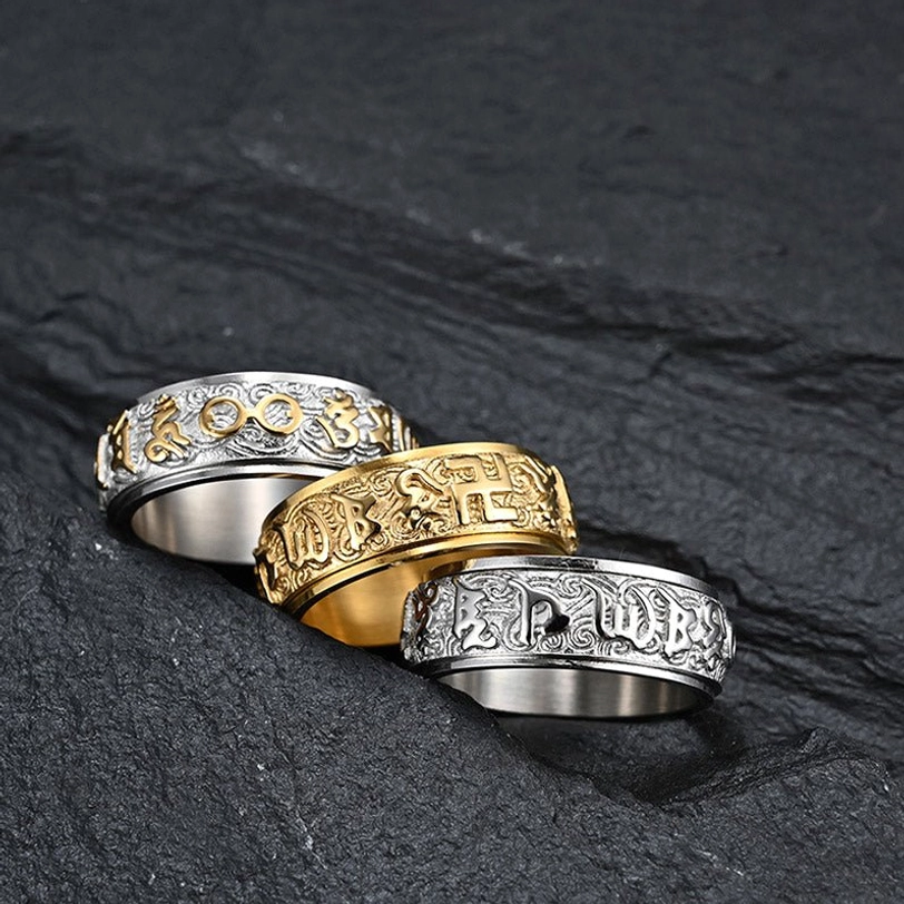 Collection of three sacred mantra spinner rings in different finishes displaying carved Sanskrit and Tibetan Buddhist designs