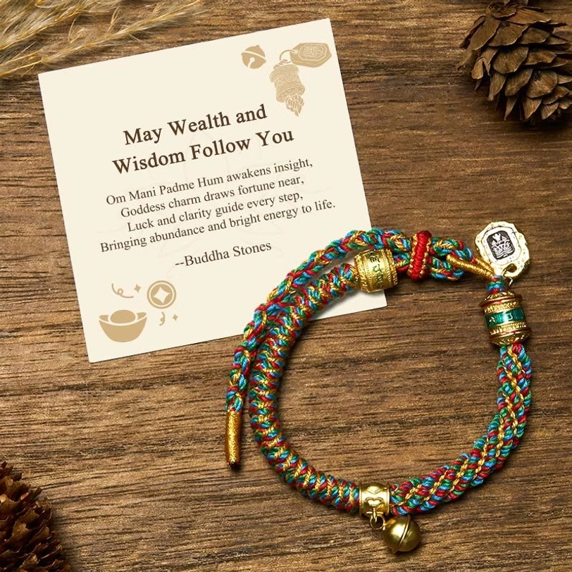Om Mani Padme Hum Tibetan wealth bracelet with multicolored braided string and Zakiram goddess charm pendant displayed on wooden surface with natural decorations