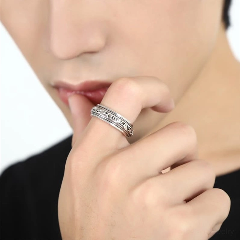 Rotatable Tibetan mantra ring worn on index finger in casual daily styling with black outfit