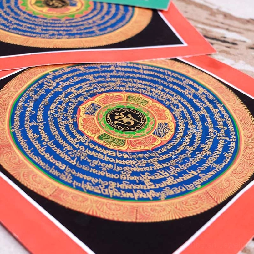 Sanskrit mantra mandala thangka with black background, red border, central Om symbol, and concentric blue gilt mantra rings