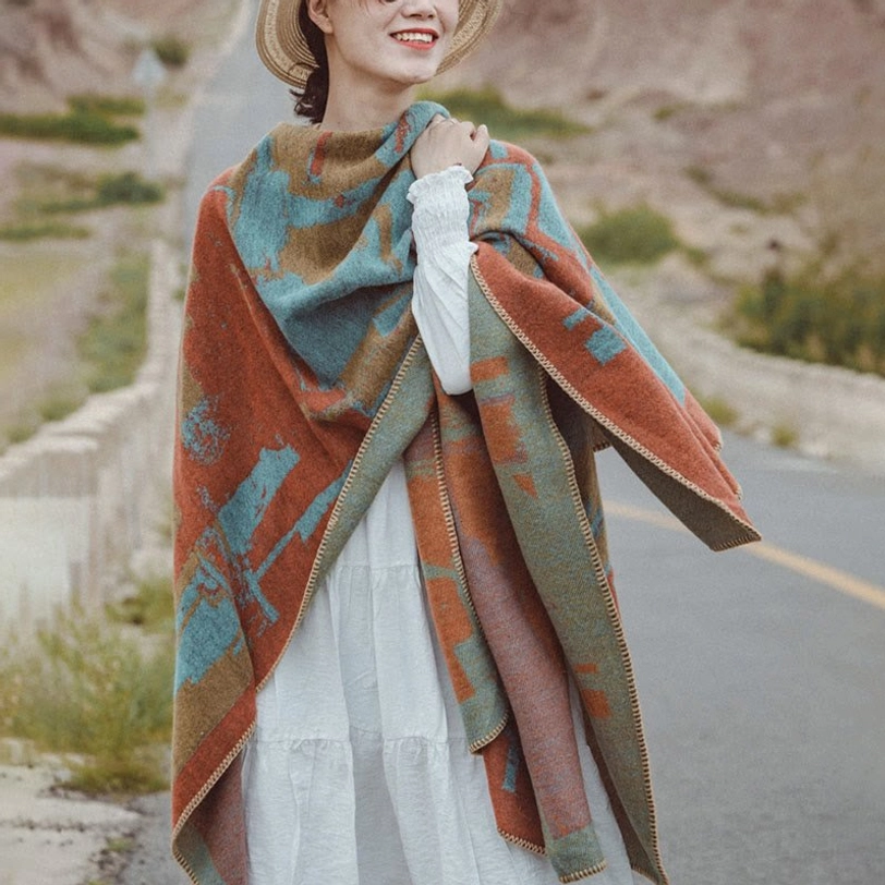 Tibetan orange geometric wool shawl worn as draped cape over vintage dress outdoors