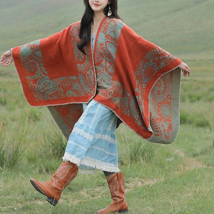 Flowy Tibetan paisley poncho with batwing sleeves draped in grassland setting, side front angle