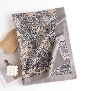 Flat lay top-down view of Tibetan ethnic scarf showing detailed black and white floral damask print on khaki base with grey borders