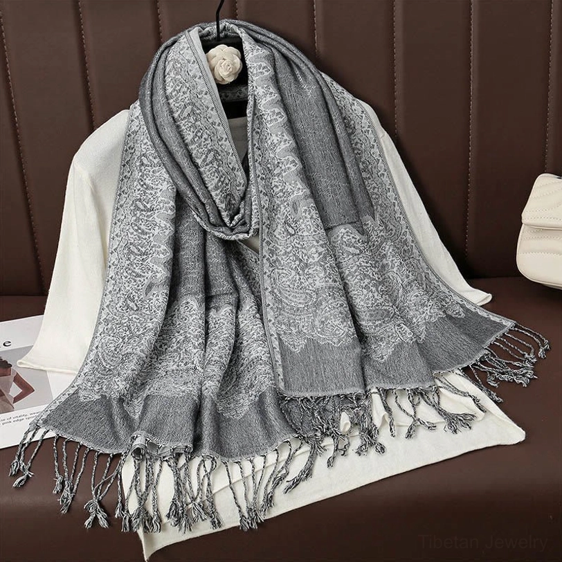 Light grey tibetan paisley tassel scarf in neutral tone showing delicate jacquard weave and fringed tassel trim