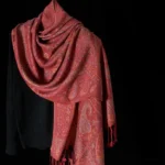 Tibetan red paisley tassel scarf draped on shoulders, showcasing intricate jacquard weave pattern and deep red-pink color
