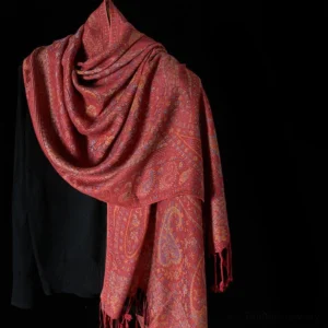 Tibetan red paisley tassel scarf draped on shoulders, showcasing intricate jacquard weave pattern and deep red-pink color