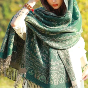 Back view of Tibetan ethnic paisley shawl with fringed hem in sunlit woodland, demonstrating soft draped fabric and authentic jacquard weave pattern