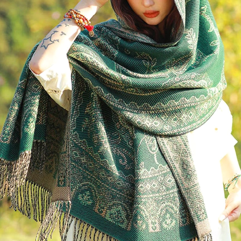 Back view of Tibetan ethnic paisley shawl with fringed hem in sunlit woodland, demonstrating soft draped fabric and authentic jacquard weave pattern