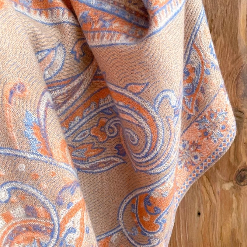 Beige Tibetan paisley tassel shawl draped showing gentle color and soft fabric texture on model