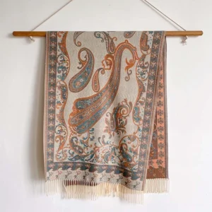 Beige Tibetan paisley thermal shawl with orange and blue print, flat laid on white backdrop showing full length and tassel detail