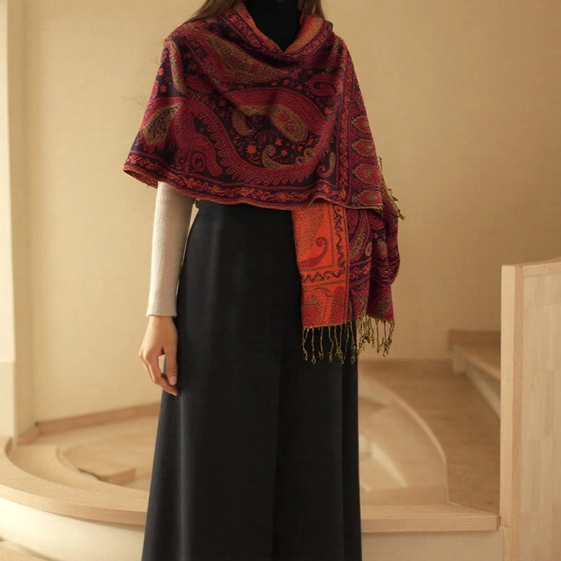 Woman wearing burgundy orange Tibetan paisley shawl with contrast collar, model front view
