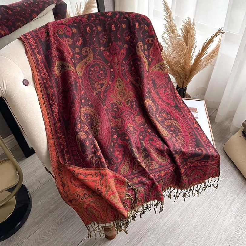 Burgundy and orange Tibetan paisley shawl overhead view showing tassel hem and color pattern