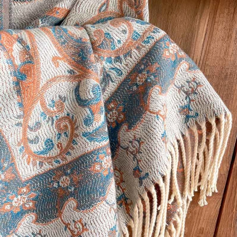 Close-up detailed view of Tibetan handwoven paisley pattern with cream tassel fringe, showing textile weave texture