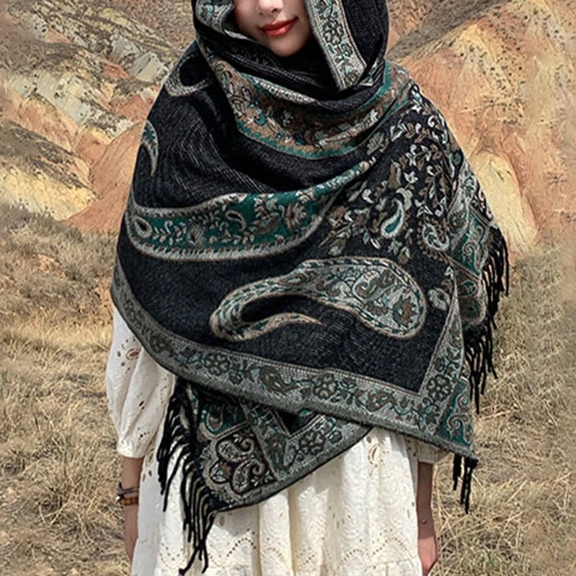 Close-up front detail of Tibetan paisley shawl showing black base with teal-brown motifs and draped wrap technique