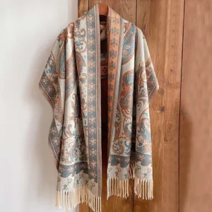 Tibetan paisley tassel shawl with cream fringe in warm retro design, displayed on wooden hanger with natural lighting
