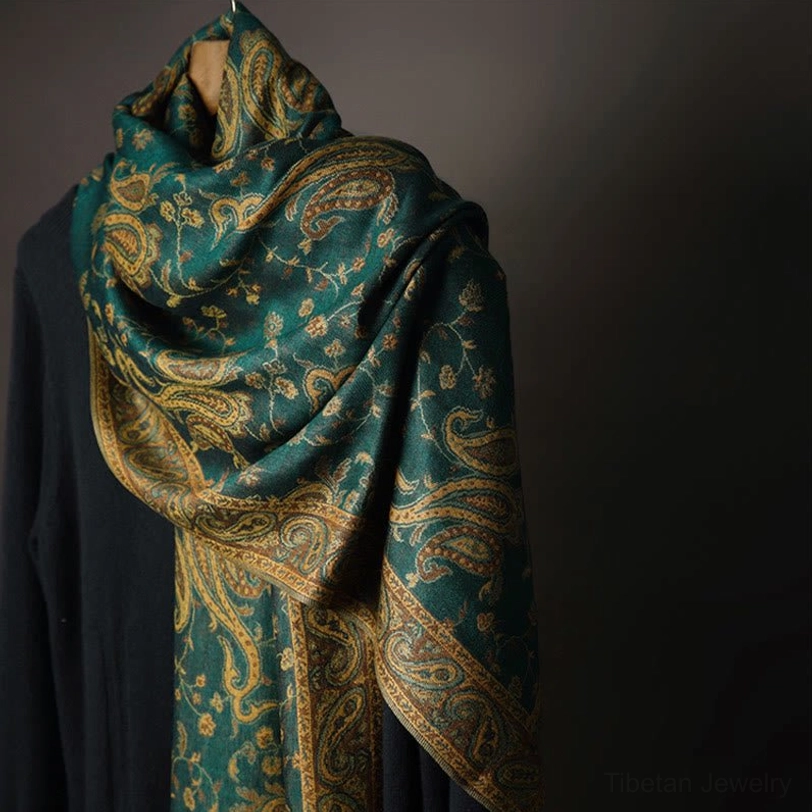 Tibetan paisley cashew flower shawl in dark green displayed on mannequin with gold-brown vintage floral pattern