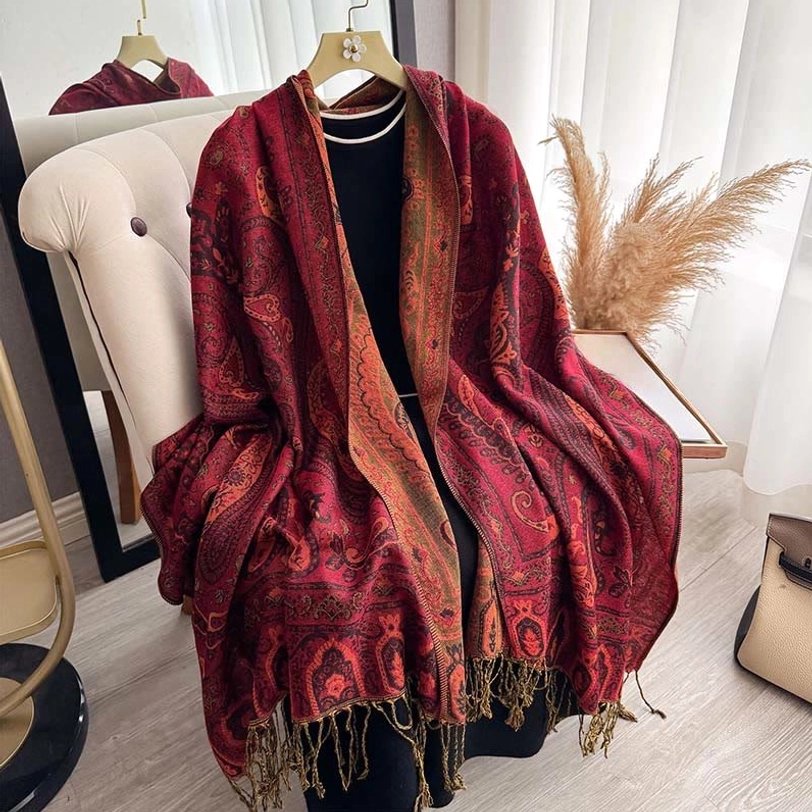 Dark red Tibetan paisley shawl with fringe trim displayed on sofa as throw blanket