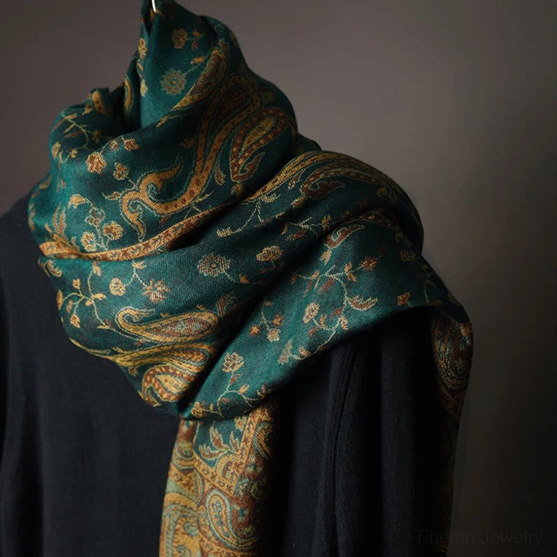 Elegantly draped tibetan paisley shawl on mannequin highlighting the vintage floral design and rich teal coloring