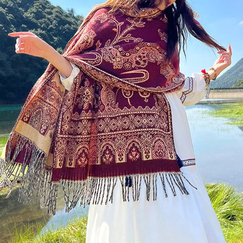 Tibetan paisley shawl worn as evening wrap demonstrating formal occasion styling and elegant tassel fringe accent