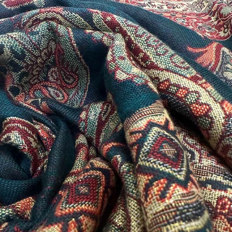 Close-up detail of Tibetan paisley shawl fabric showing intricate jacquard weaving and geometric patterns
