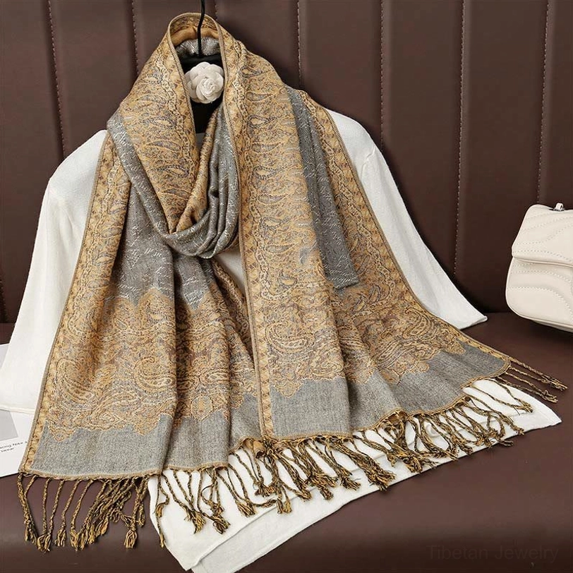 Gold-toned tibetan paisley jacquard tassel shawl detail shot showing intricate woven pattern and golden hues