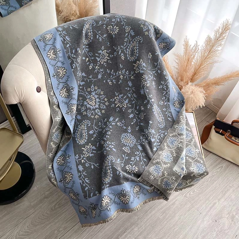 Tibetan grey paisley shawl with blue pattern displayed on mannequin in home lounge