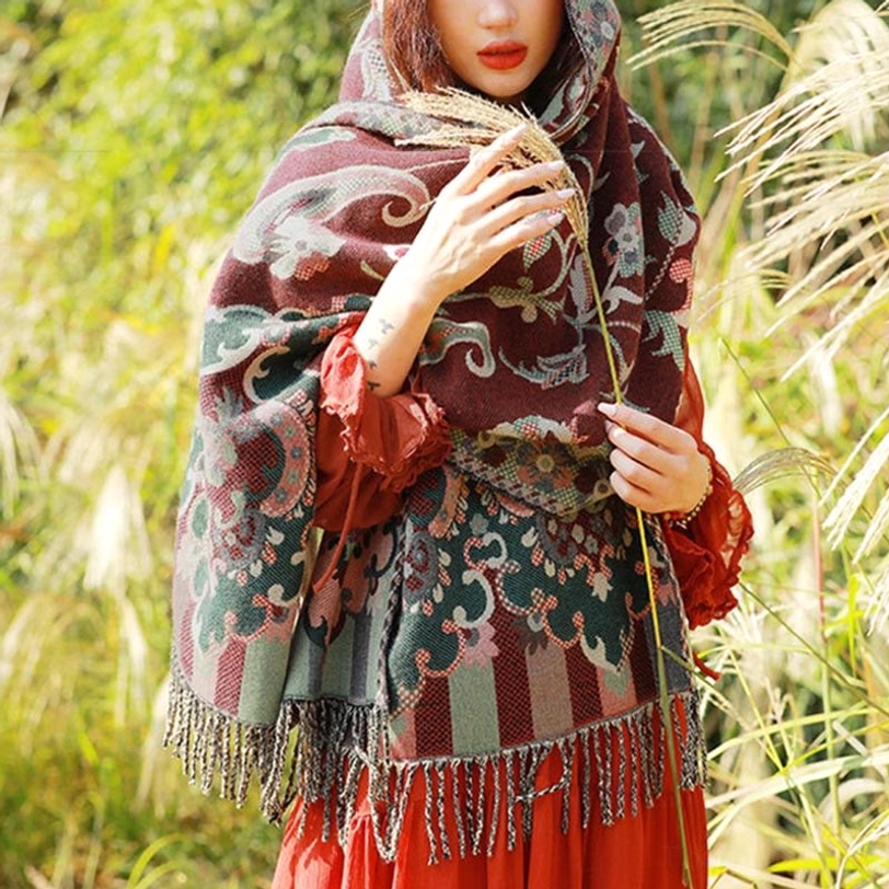 Deep maroon Tibetan paisley shawl with green and pink paisley patterns worn in reed grass field, paired with red ruffled dress