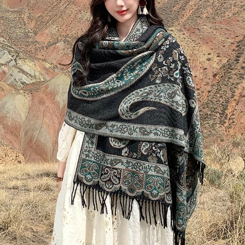 Tibetan paisley tassel shawl in dark teal worn on-body outdoors, showing front wrap style with mountain landscape background