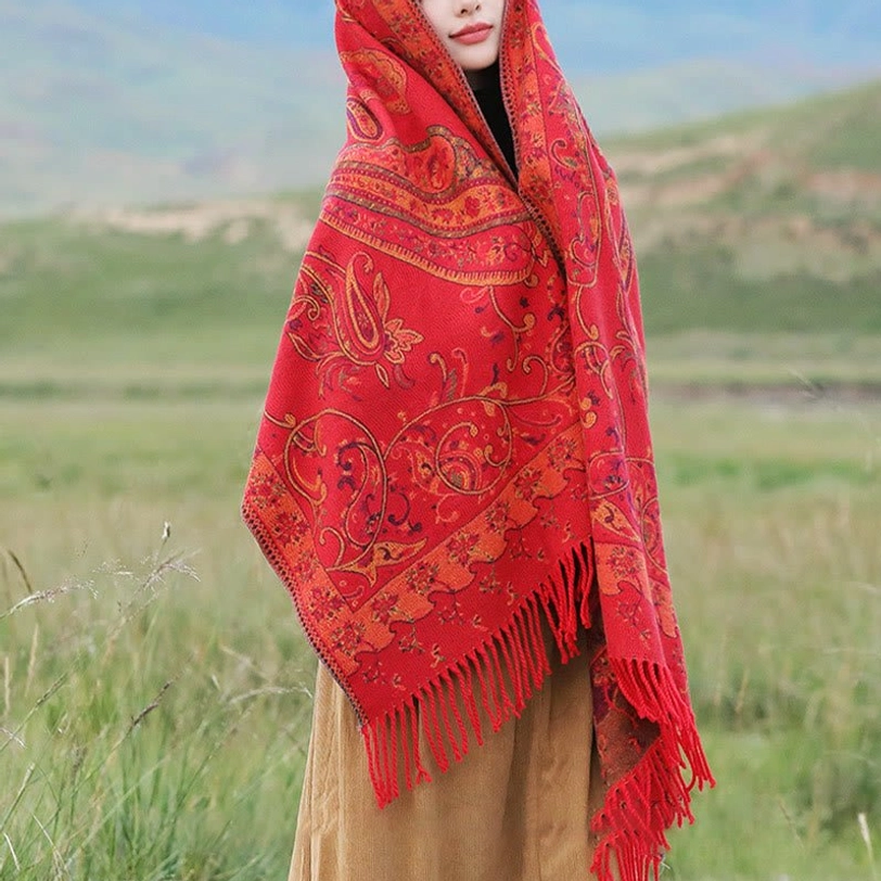 Red Tibetan tassel shawl close-up detail showing fine weave quality and paisley pattern in warm tones