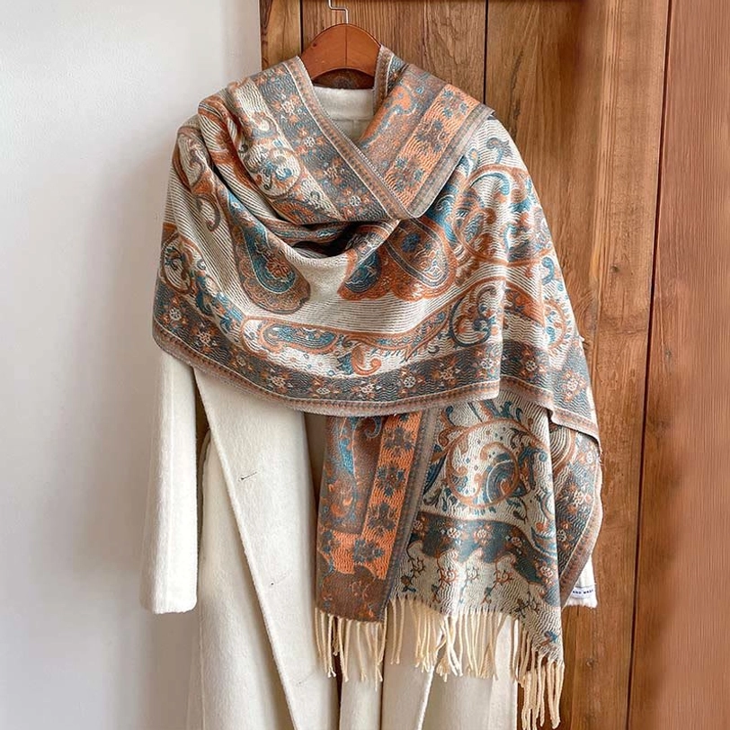 Tibetan paisley tassel shawl draped over white coat, showcasing styling versatility and warm color coordination