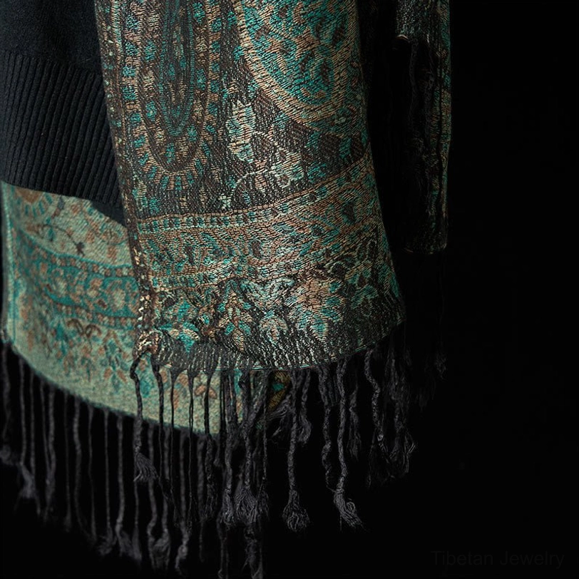 Tibetan paisley shawl hem detail with black tassel fringe and woven border, artisan craftsmanship