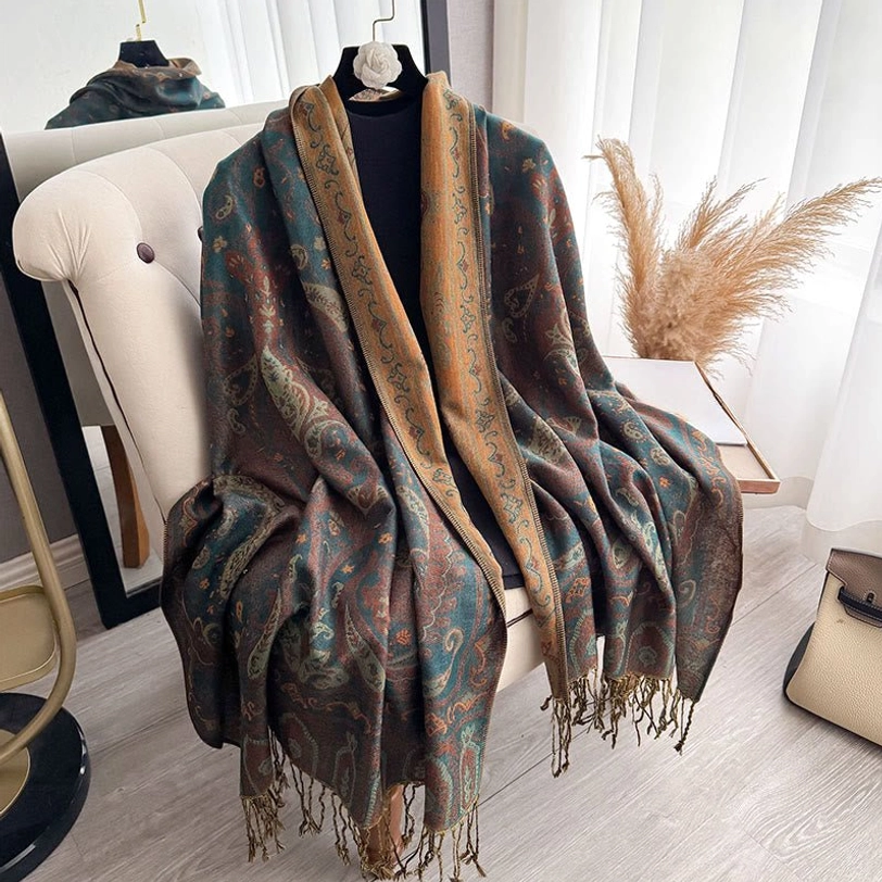 Teal and mustard Tibetan paisley shawl displayed on dress form near sofa, showing full design