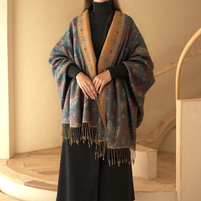 Woman wearing teal and mustard Tibetan paisley tassel shawl with contrast collar, full front view